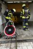Quelle: FFw Freising  - Atemschutztrupp mit Hochleistungslüfter auf dem Weg in die Tiefgarage